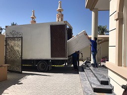 A team member moving sofa to truck